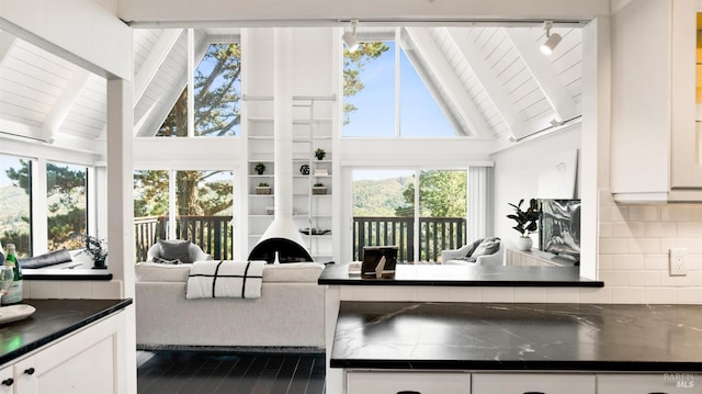 sunroom / solarium featuring lofted ceiling with beams and wood ceiling