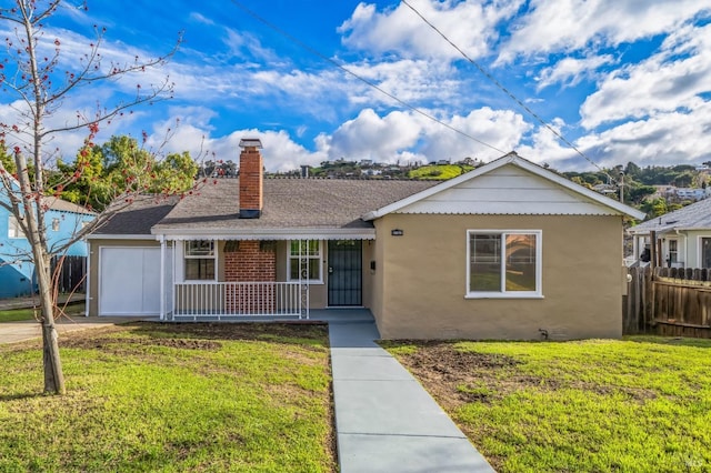 ranch-style house featuring covered porch, a shingled roof, fence, a chimney, and a front yard