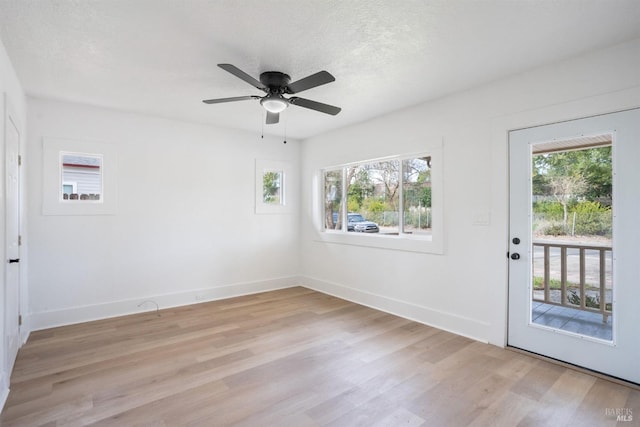 unfurnished room featuring baseboards, light wood-style flooring, and a healthy amount of sunlight