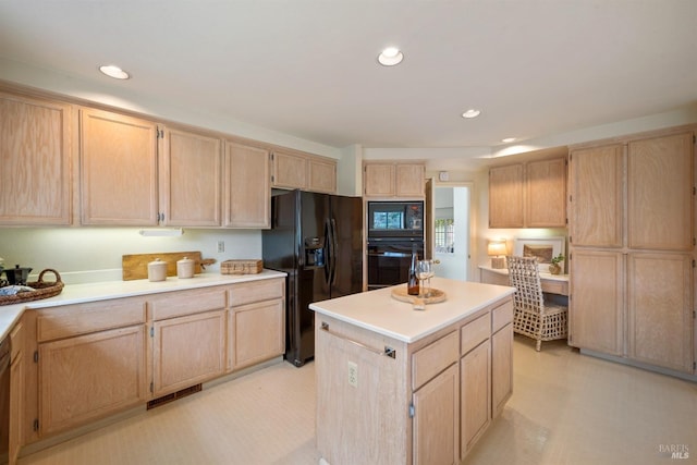 kitchen featuring visible vents, a center island, light countertops, light brown cabinetry, and black appliances