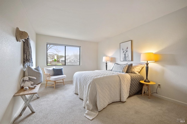 bedroom featuring light carpet and baseboards