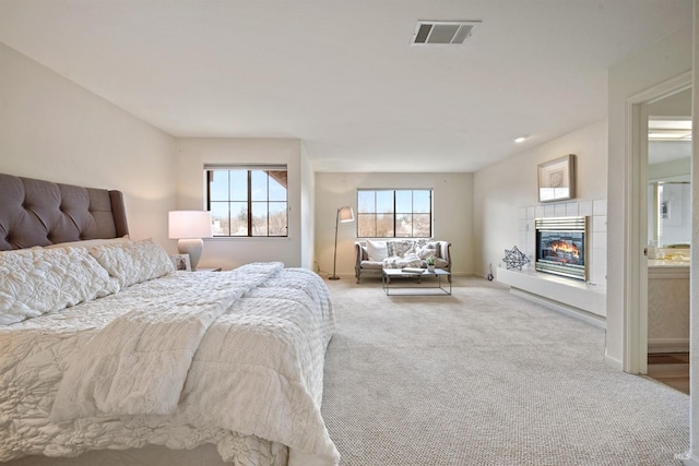 bedroom featuring carpet, visible vents, baseboards, and a tile fireplace