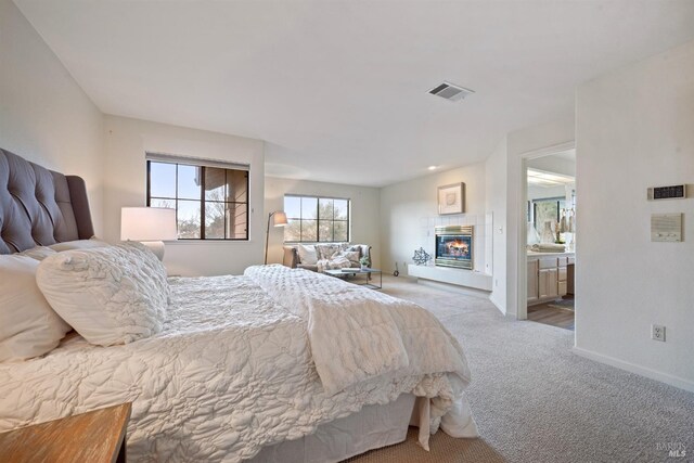 bedroom featuring baseboards, visible vents, a tiled fireplace, and carpet flooring