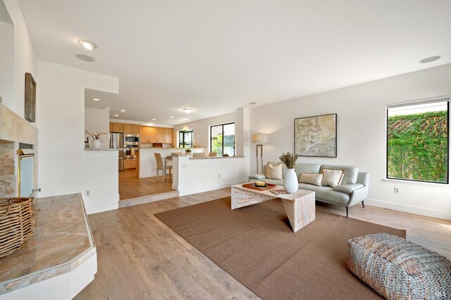 living room with light wood-style floors, recessed lighting, and baseboards