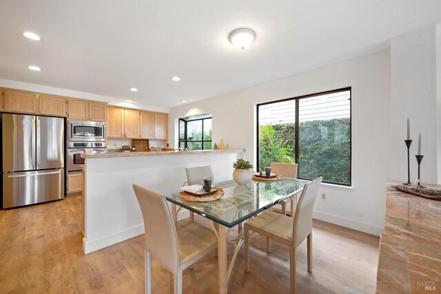 dining room with recessed lighting, baseboards, and light wood finished floors