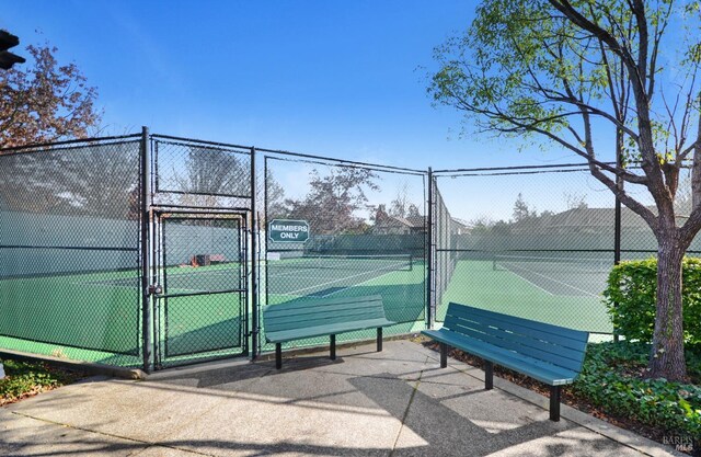 view of sport court with a gate and fence