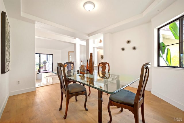 dining space featuring light wood-type flooring and baseboards