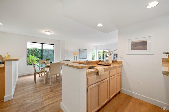 kitchen featuring recessed lighting, baseboards, a peninsula, and light wood finished floors