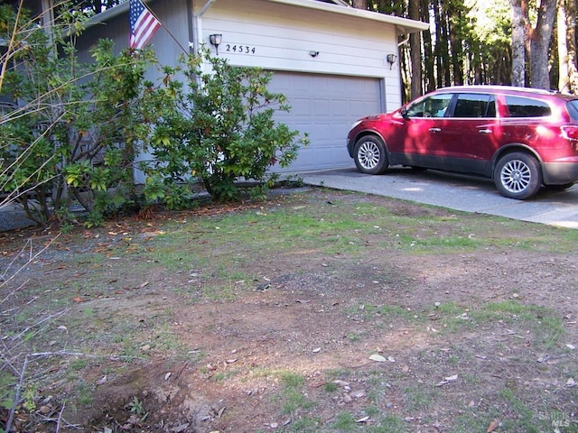 view of yard featuring driveway and a garage