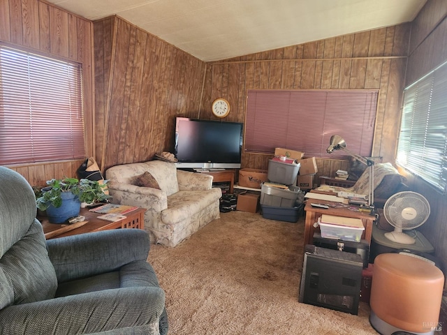 living room featuring wooden walls, lofted ceiling, and carpet floors