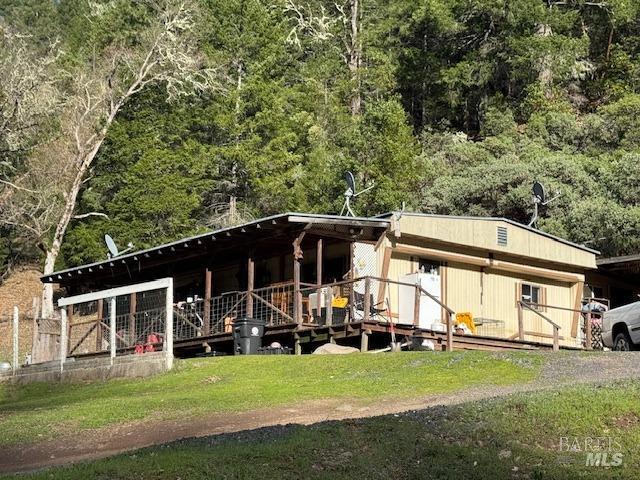 exterior space with gravel driveway and a wooded view