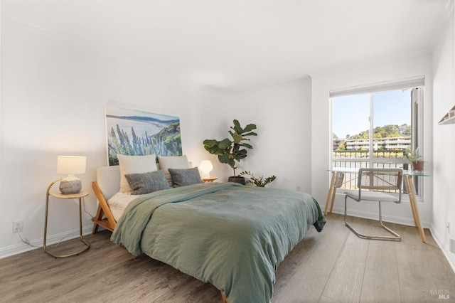 bedroom with baseboards and wood finished floors