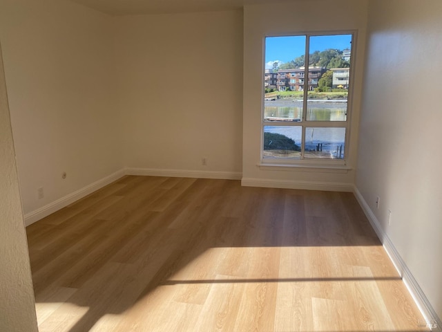 spare room with wood finished floors and baseboards