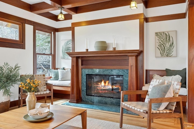 living area featuring wood finished floors, coffered ceiling, beam ceiling, and a premium fireplace