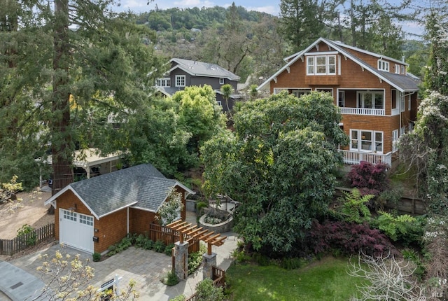 exterior space featuring driveway, fence, and roof with shingles