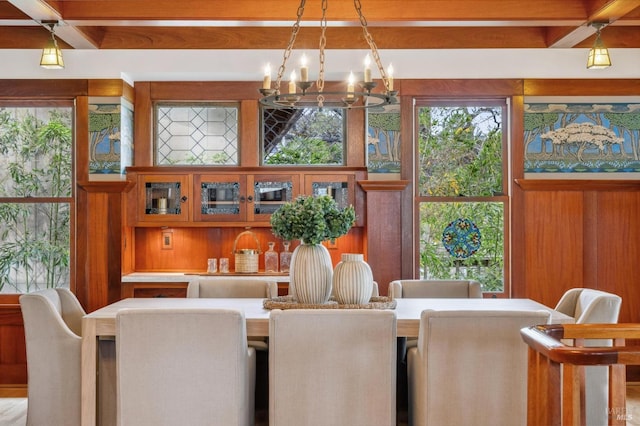 dining area with plenty of natural light, beam ceiling, and an inviting chandelier