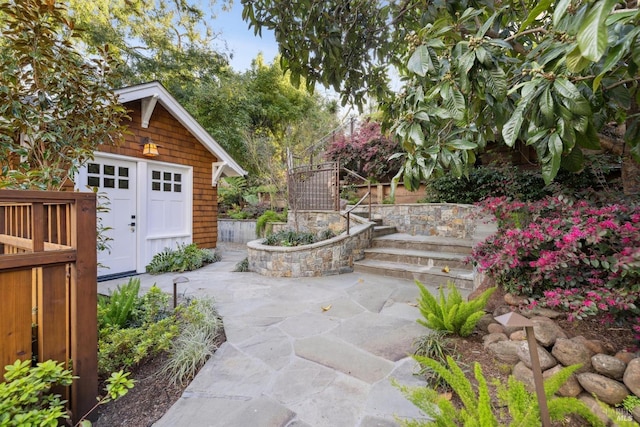 view of patio / terrace with an outbuilding and fence