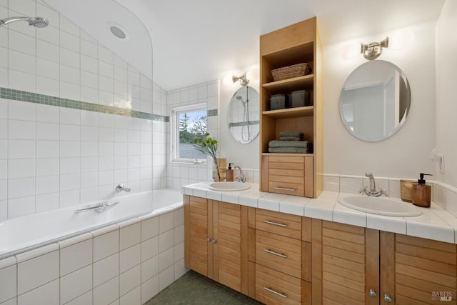 bathroom featuring a relaxing tiled tub, vaulted ceiling, a sink, and double vanity