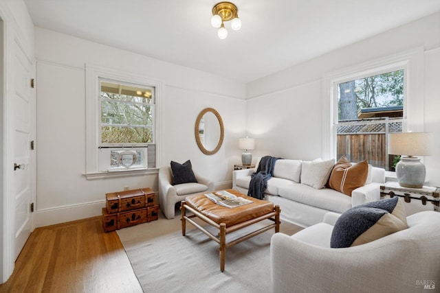 living area with baseboards and wood finished floors