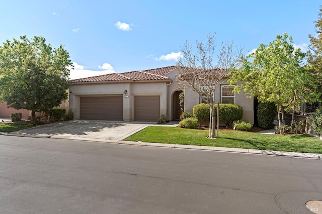 mediterranean / spanish-style home featuring driveway, a tile roof, an attached garage, a front lawn, and stucco siding