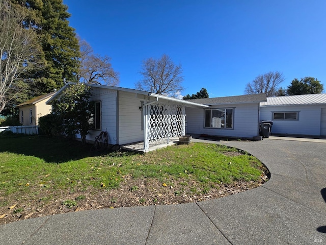 ranch-style house with aphalt driveway and a front lawn