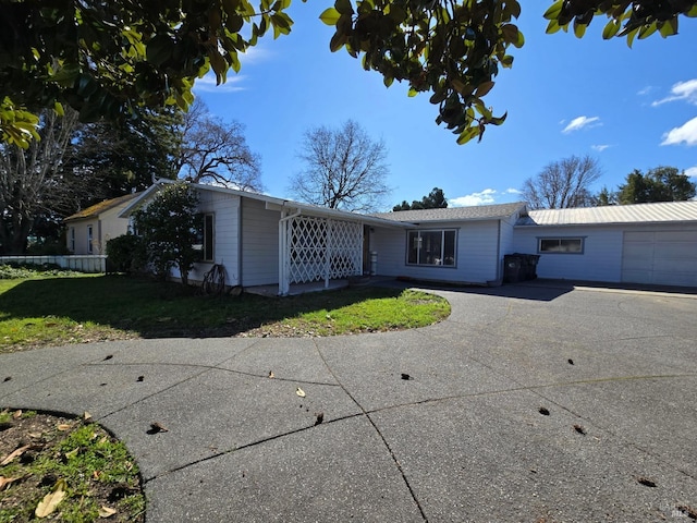 ranch-style house featuring a front yard, driveway, and an attached garage