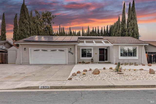 single story home featuring a garage, a tile roof, fence, and stucco siding