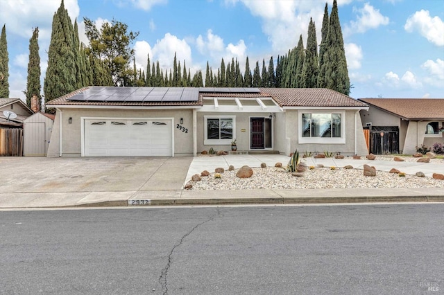 ranch-style house featuring an attached garage, fence, a tiled roof, concrete driveway, and stucco siding