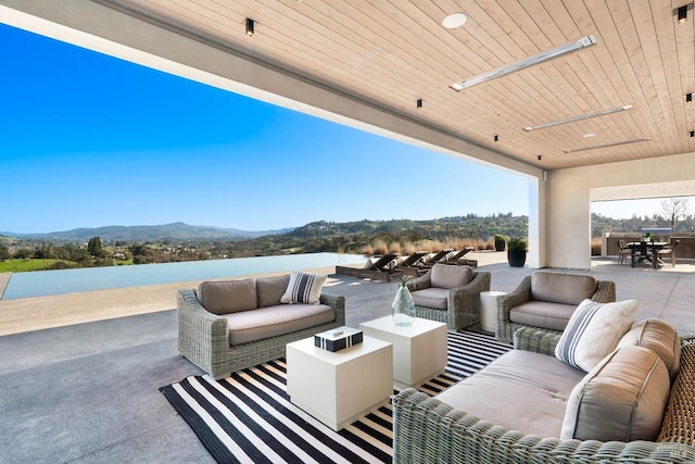 view of patio / terrace with an outdoor hangout area, outdoor dining area, and a water and mountain view