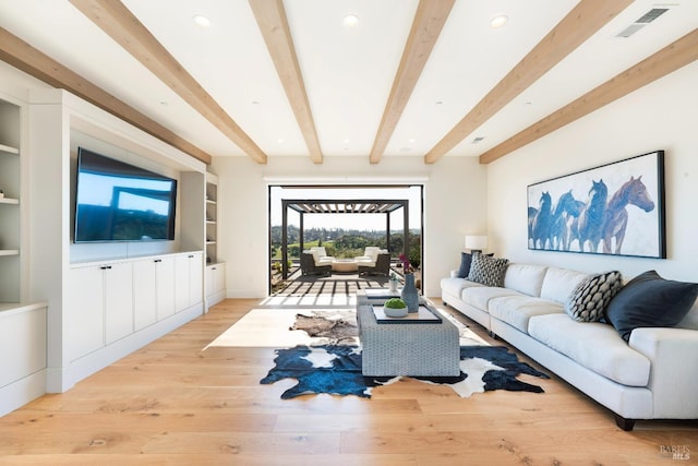 living area with visible vents, beam ceiling, built in features, and wood finished floors