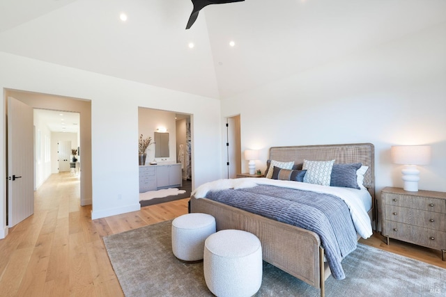 bedroom featuring high vaulted ceiling, baseboards, connected bathroom, and light wood finished floors