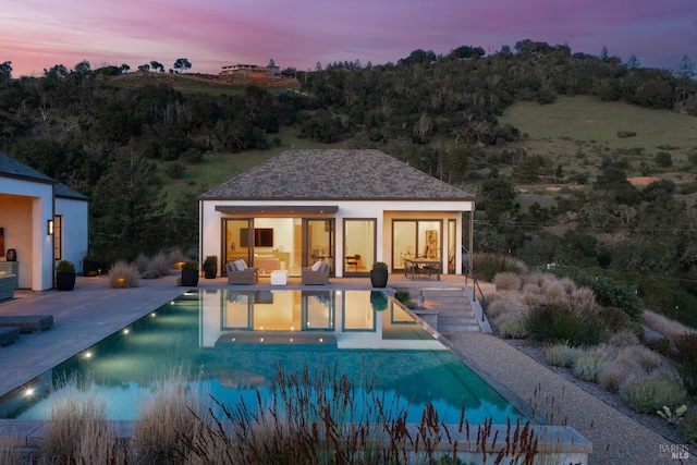 exterior space featuring a patio, a storage structure, an outdoor structure, and an outdoor pool