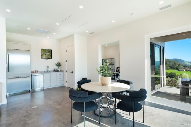 dining room featuring finished concrete flooring, wet bar, visible vents, and recessed lighting