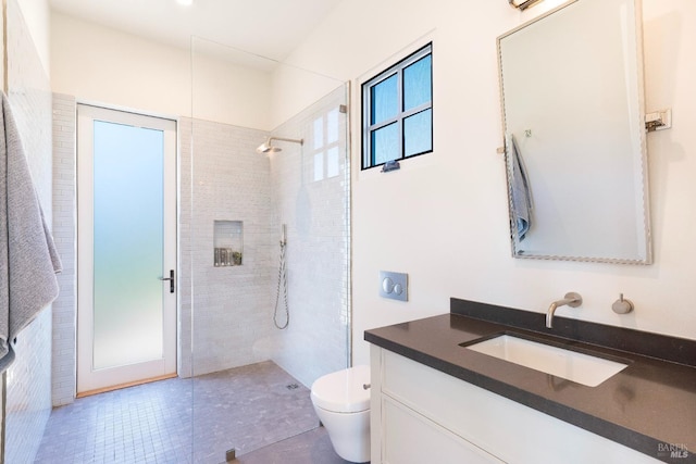 bathroom with tile patterned floors, vanity, toilet, and a walk in shower