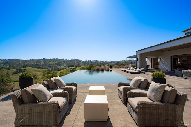 view of pool with a patio area, an infinity pool, outdoor lounge area, and a water view