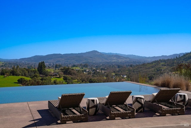 view of swimming pool with a mountain view