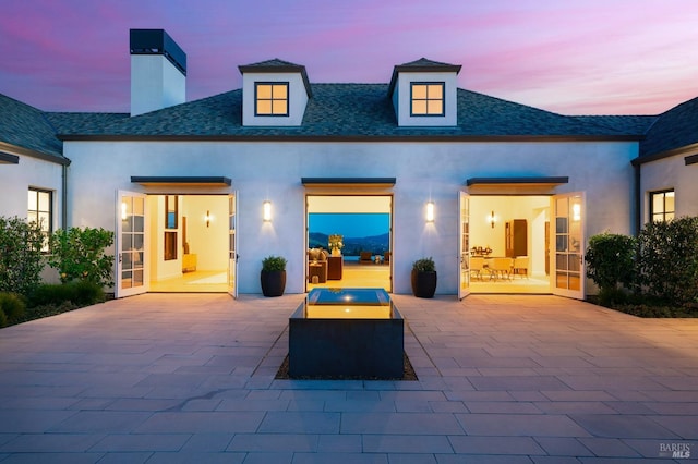 rear view of property with a patio and stucco siding