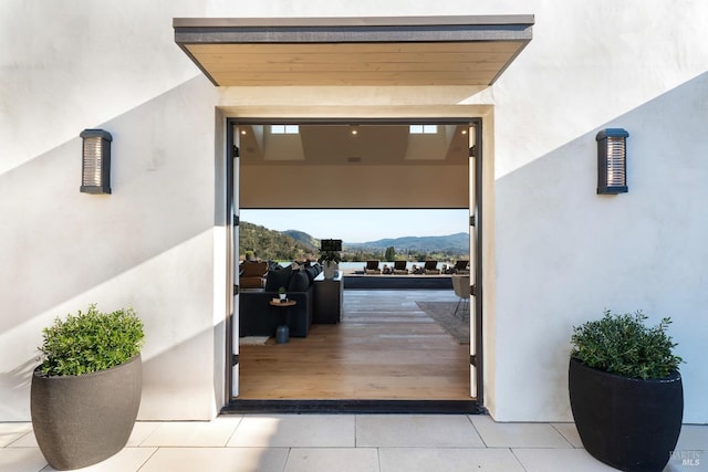 entrance to property with a mountain view and stucco siding