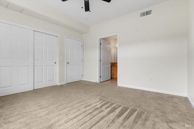 unfurnished bedroom featuring connected bathroom, carpet flooring, visible vents, baseboards, and a closet