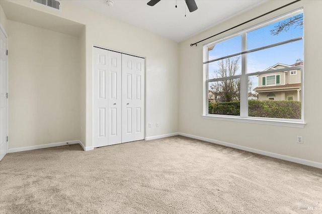 unfurnished bedroom featuring baseboards, a closet, visible vents, and carpet flooring