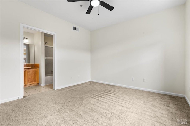 unfurnished bedroom with baseboards, light tile patterned floors, visible vents, and light colored carpet