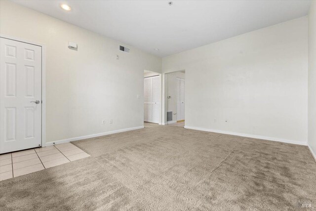 carpeted empty room featuring recessed lighting, visible vents, and baseboards