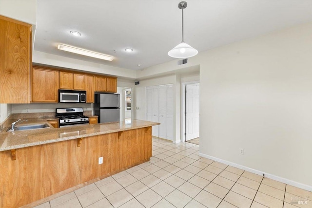 kitchen featuring light tile patterned floors, stainless steel appliances, a peninsula, a sink, and visible vents