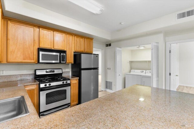 kitchen featuring stainless steel appliances, light countertops, light tile patterned flooring, and a sink