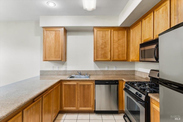 kitchen with brown cabinetry, light countertops, stainless steel appliances, a sink, and light tile patterned flooring