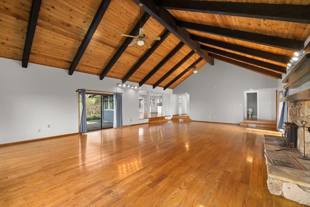 unfurnished living room with wooden ceiling, wood finished floors, a ceiling fan, baseboards, and beamed ceiling