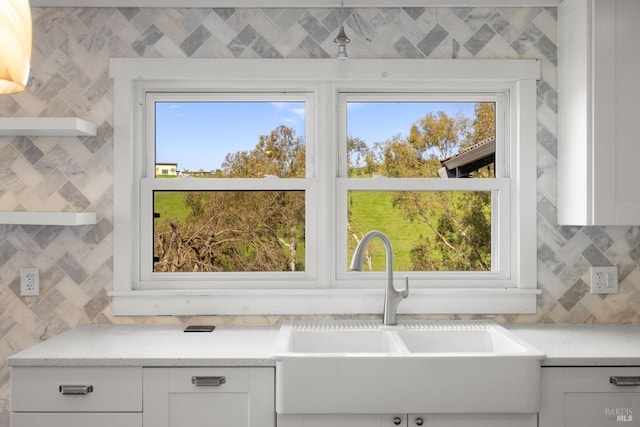 details with white cabinetry, a sink, decorative backsplash, and open shelves