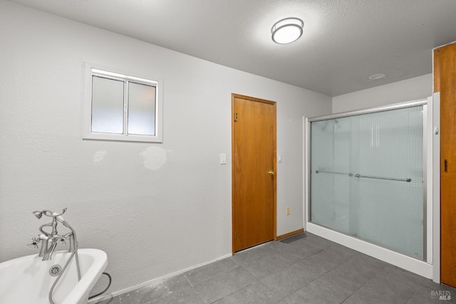 bathroom featuring a freestanding tub, a shower stall, and baseboards