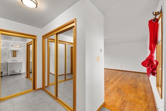 hall with baseboards and wood finished floors