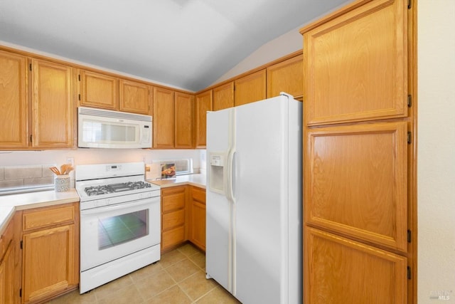 kitchen featuring light tile patterned flooring, white appliances, light countertops, and vaulted ceiling